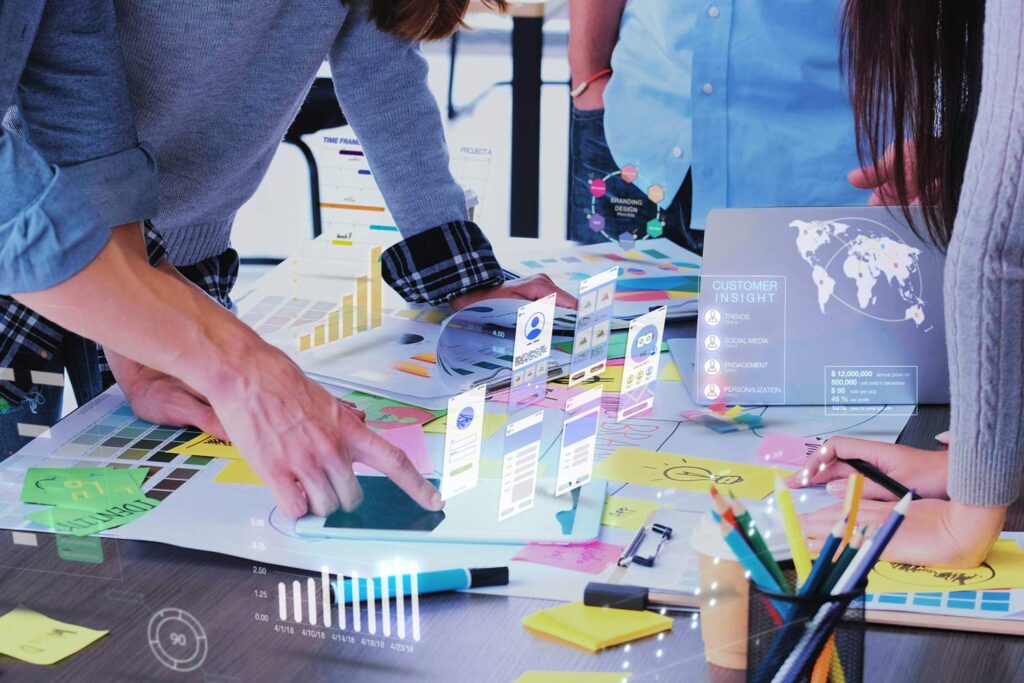 Two people working at a table with user experience drawings